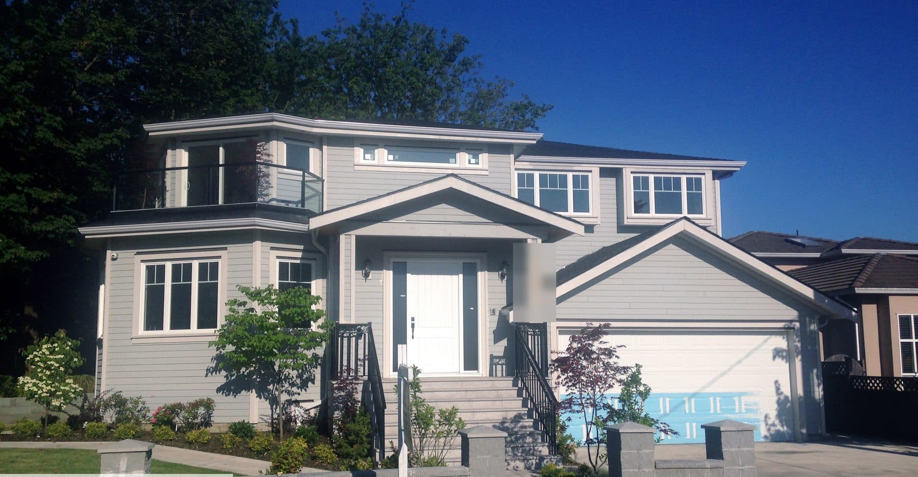 Transitional single-family home in a light grey palette with a covered entry