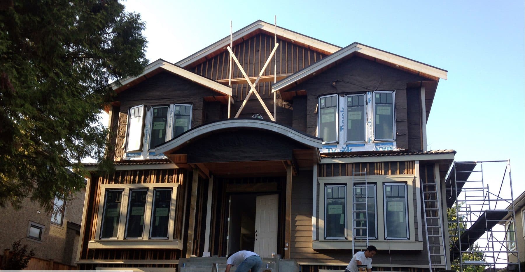 Craftsman single-family home under construction with gables and exposed brackets